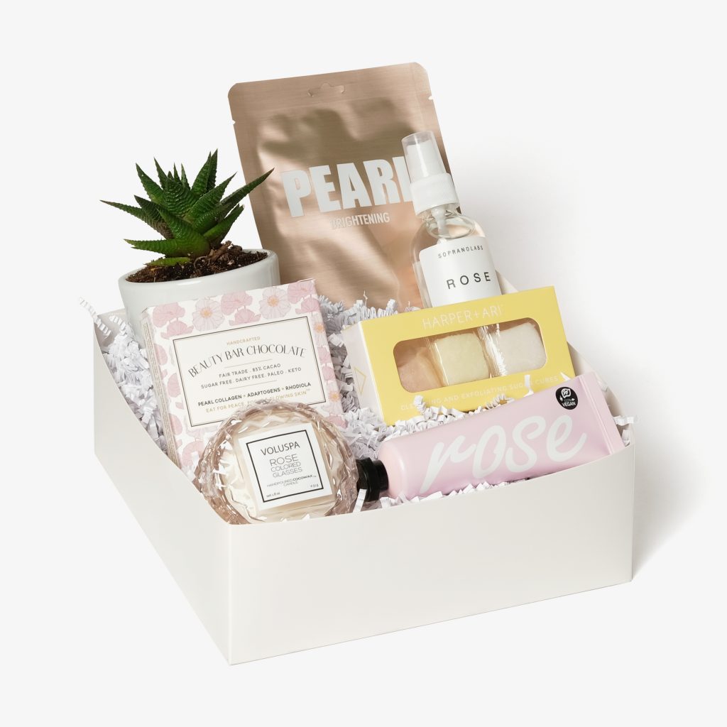 spa day gift box featuring chocolate, succulent plant, face mask, a small round candle, and toner
